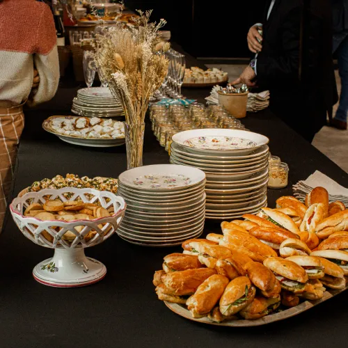 Un déjeuner cocktail avec des mini-sandwichs, pains toastés et assiettes