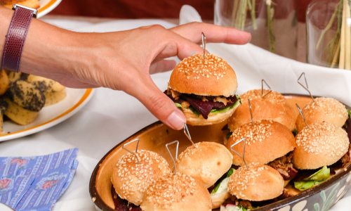 Main qui saisit un mini burger végétarien